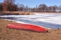 Red old boat on early lake coast and ice Royalty Free Stock Photo