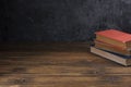 Red old books Blue and green on the old wooden table Black wall background and there is space for writing messages Royalty Free Stock Photo