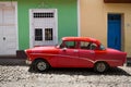 Red old car in front of colourful houses, Cuba Royalty Free Stock Photo
