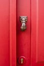 Red old door with doorknocker Metal arm of woman or man Royalty Free Stock Photo