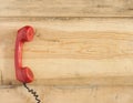 Red old fashioned telephone receiver on wooden table Royalty Free Stock Photo