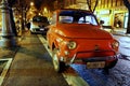 Red old Fiat 500 parked on the street at night Royalty Free Stock Photo