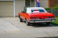 Red old historic car parked in a driveway with a white convertible roof has a for sale sign in its rear window Royalty Free Stock Photo