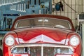 Red oldtimer car parked in a repair shop in front of a wall with screw-wrenches Royalty Free Stock Photo