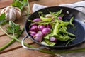 Red onion, garlic, and green peas in frying pan with leek around Royalty Free Stock Photo