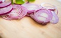 Red onion slices isolated on wooden chopping board Royalty Free Stock Photo