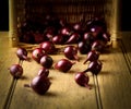 Red onion vegetables with wicker basket in background on rustic Royalty Free Stock Photo