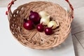 Red onion and white onion brown wicker basket Royalty Free Stock Photo