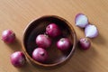 Red onion in wood bowl and on wooden surface background Royalty Free Stock Photo