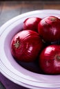 Red onions in a purple bowl