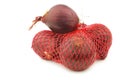 Red onions in a red plastic net Royalty Free Stock Photo