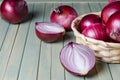 Red onions in a wicker basket. Fresh harvest. Light wood background Royalty Free Stock Photo