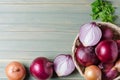 Red onions in a wicker basket. Fresh harvest. Light wood background Royalty Free Stock Photo