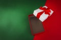 Red open gift box with ribbon on green and red Christmas background Royalty Free Stock Photo