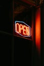 Red open neon sign glowing in the night