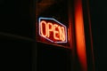 Red open neon sign glowing in the night