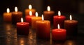 Red and Orange Candles Burning on Dark Table Royalty Free Stock Photo