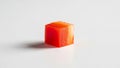 Red orange cube of bell pepper Capsicum annuum rests on a plain Royalty Free Stock Photo