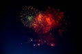 Red and orange fireworks with green sparks inside and smoke on the background of the night sky Royalty Free Stock Photo