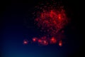 Red and orange fireworks with green sparks inside and smoke, below you can see small fireworks against the night sky Royalty Free Stock Photo