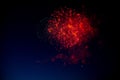 Red and orange fireworks with green sparks inside and smoke, below you can see small fireworks against the night sky Royalty Free Stock Photo