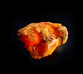 Red orange gypsum mineral crystal from Luban, Belarus. A backlight photo of a stone isolated on black. Geology websites