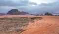 Red orange Mars like landscape in Jordan Wadi Rum desert, mountains background, overcast morning. This location was used Royalty Free Stock Photo