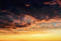 Red orange reflections of the setting sun on dark thunderclouds. Scenic storm clouds lit by the last rays of the sunset. Dramatic Royalty Free Stock Photo