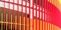Red and orange scaffolds cover white wall with metal grid