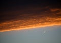 Red and orange clouds at sunset with jet aircraft vapour trail