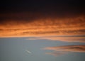 Red and orange clouds at sunset with jet aircraft vapour trail