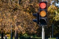 Red and orange traffic light in semaphore closeup. Bright colored autumn background Royalty Free Stock Photo