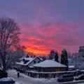 Red orange winter sky - sunset in the small snowy town