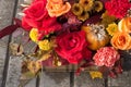 Red orange yellow autumn bouquet with pink rose flowers, fall leaves and pumpkin close up in box by professional florist Royalty Free Stock Photo