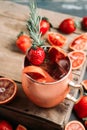 Red oranges and strawberry cocktail in copper mug variation of Moscow mule on the wooden background Royalty Free Stock Photo