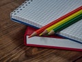 Red organizer, checkered notepad and colored pencils