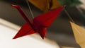 Red origami bird garland stork on light background