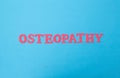 Red osteopathy word on blue background. Alternative medicine section concept treating a person. Craniosacral therapy and