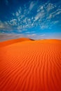 Red sand dune with ripple and blue sky Royalty Free Stock Photo