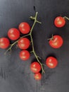 Red pachino tomatoes grape on a bÃÂ²ack wooden background