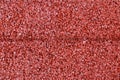 red padded granular soft rubber tile safety, playground and sport floor closeup detail.