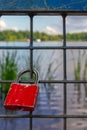 a red padlock with a natural lake behind it