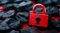 A red padlock sitting on top of a pile of black rocks Royalty Free Stock Photo