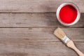 Red paint in the bank to repair and brush on the old wooden background with copy space for your text. Top view Royalty Free Stock Photo