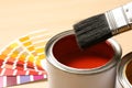 Red paint can, brush and color palette on table, closeup. Royalty Free Stock Photo