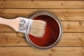Red paint can with brush on wooden floor Royalty Free Stock Photo
