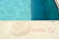 Red paint inscription no diving for safety on the background of the pool on a tropical warm sea resort and copy space