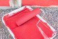 Red paint in tray with roller by old barn Royalty Free Stock Photo