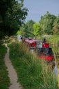 Moored red canal barge in English countryside.