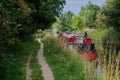 Moored red canal barge in English countryside.